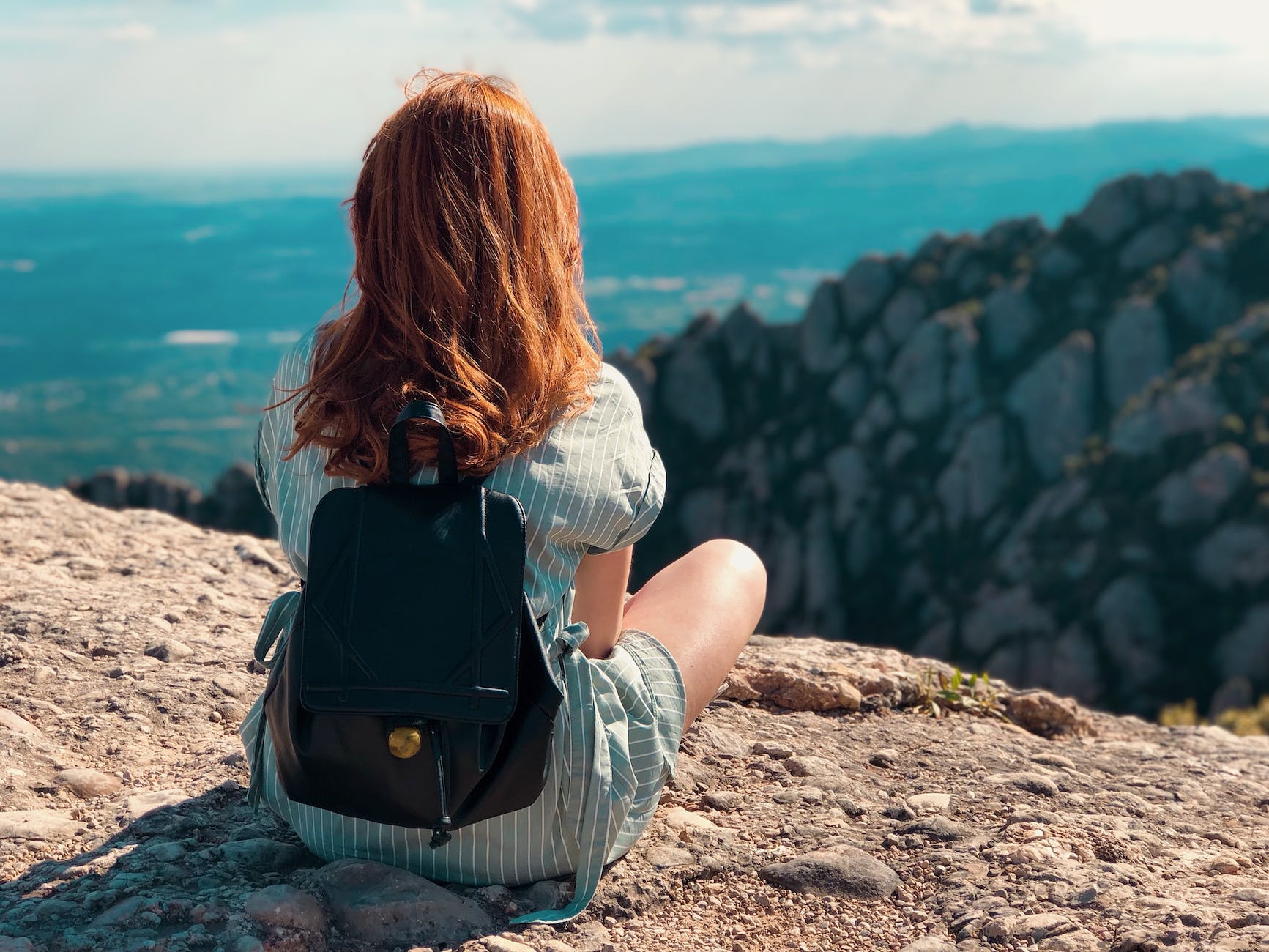 woman at edge of cliff looking at sea