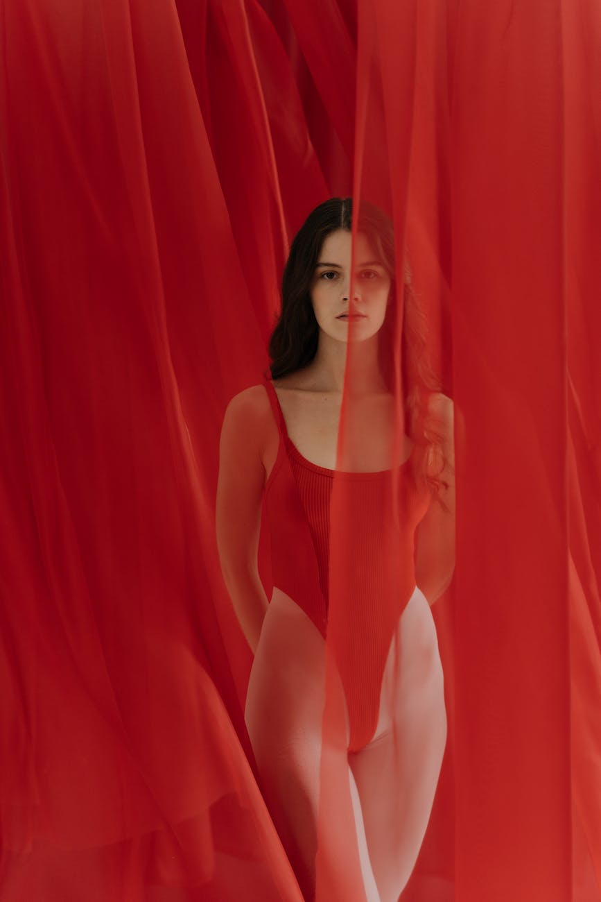 woman posing among red curtains