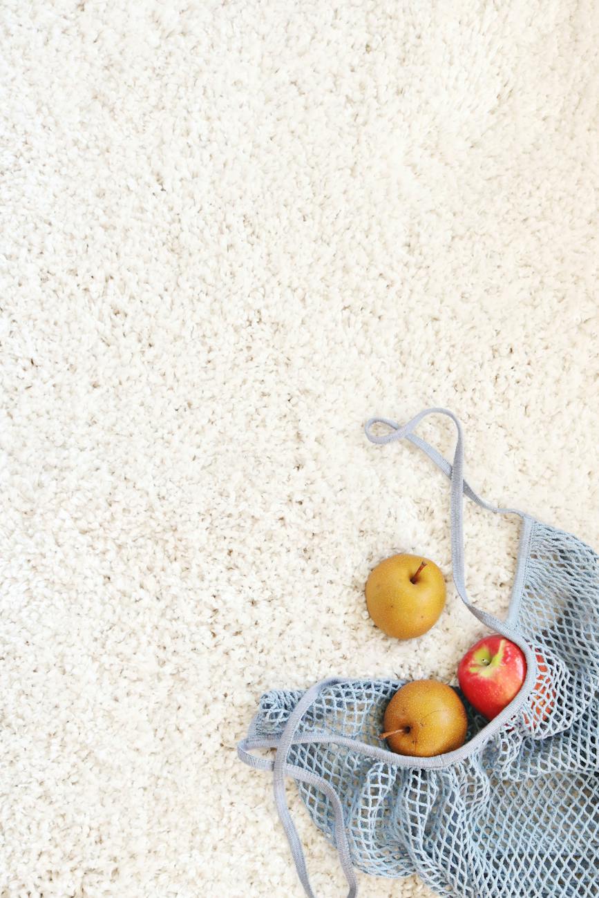 three apples on white rug