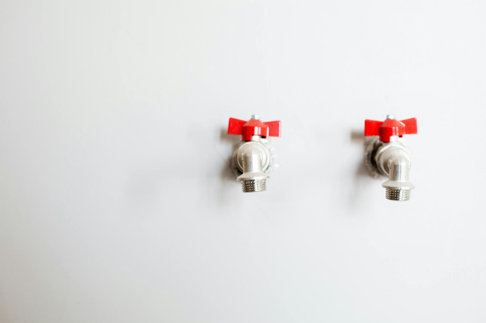 faucets on white wall