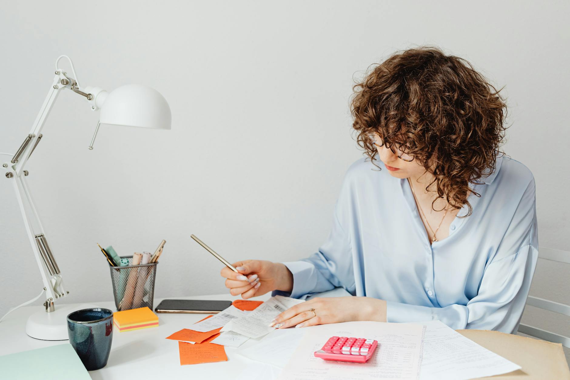 woman checking receipts on wooden table