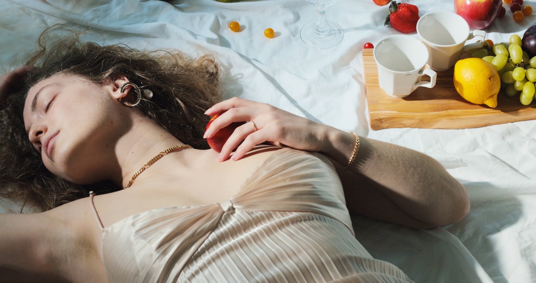 relaxed woman with fruit lying on blanket