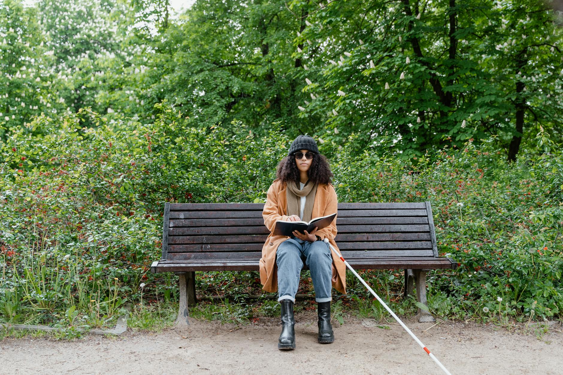 woman sitting on bench while holding a book
