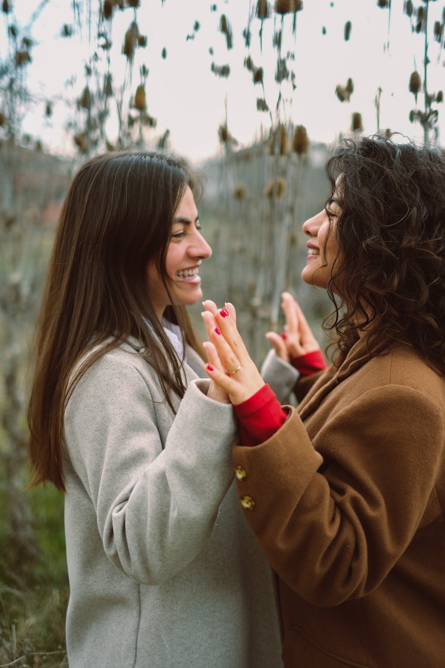 smiling women in coats holding hands