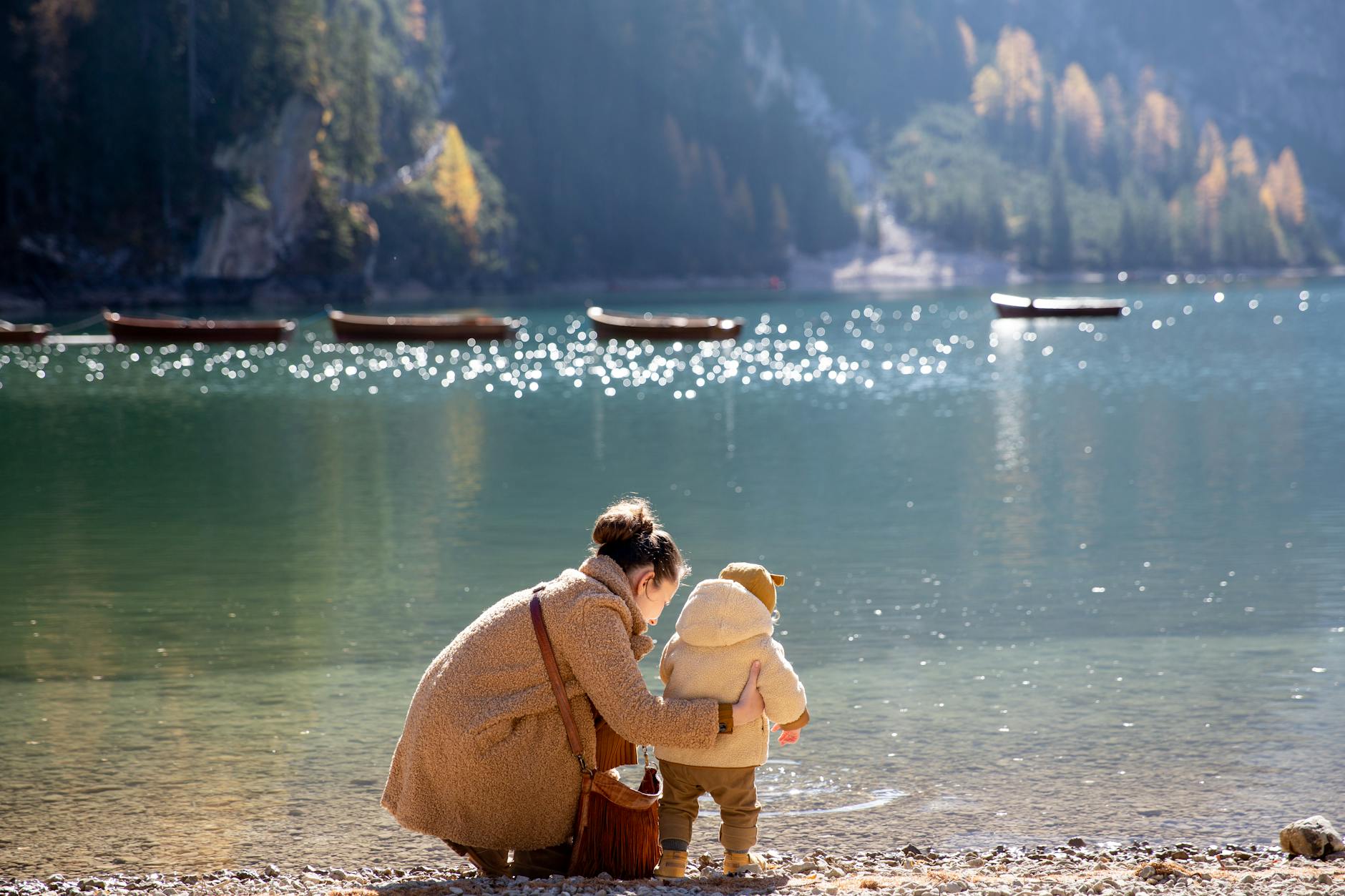 mother and child near body of water