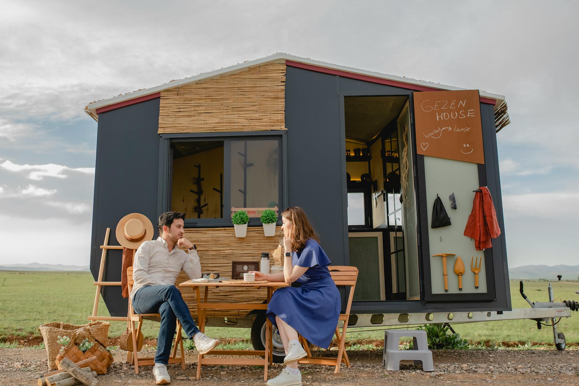 young couple sitting at table in front of mobile home