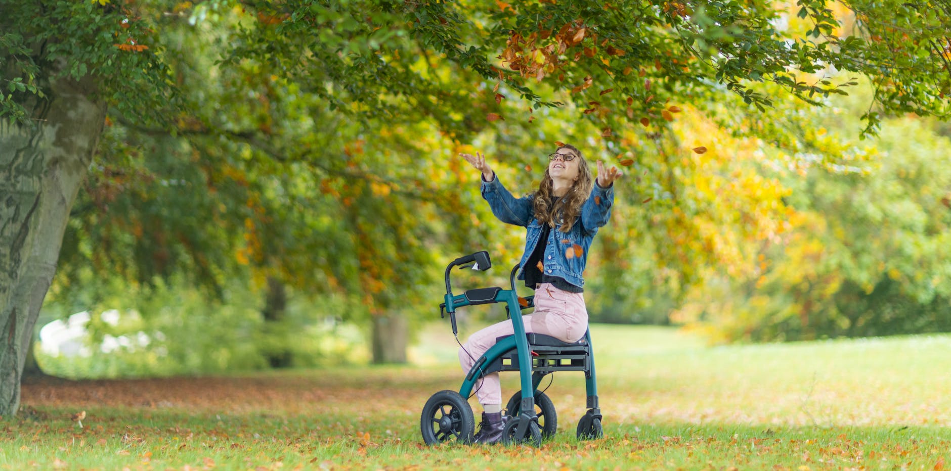 woman sitting on walking frame under tree
