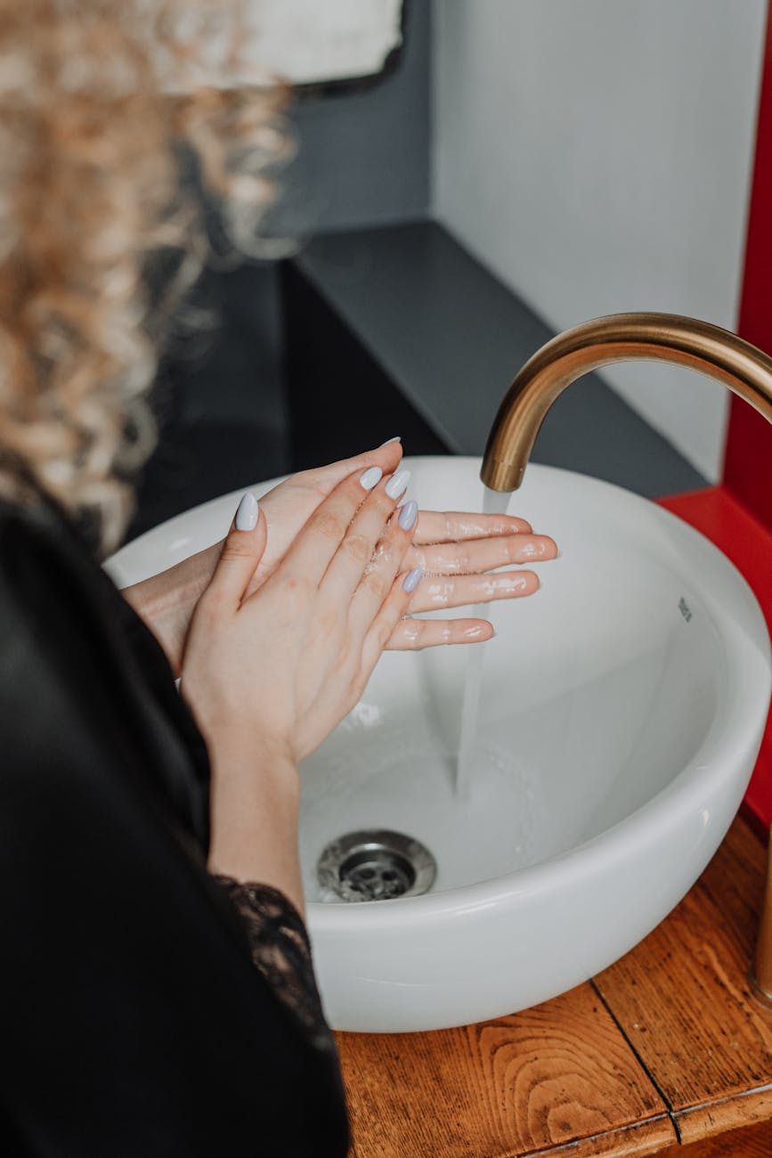 person washing hand on sink