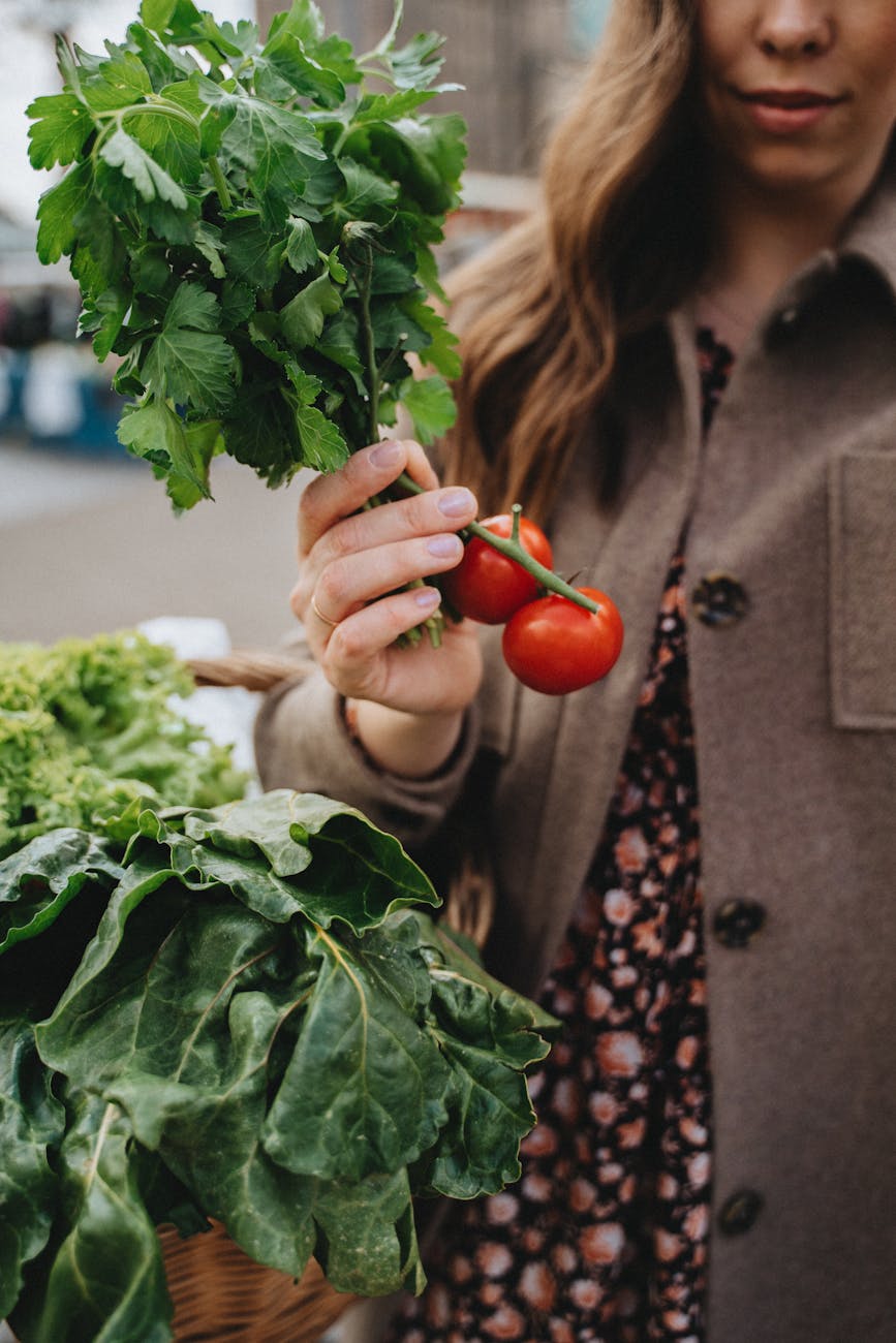 woman holding a branch of tomatoes