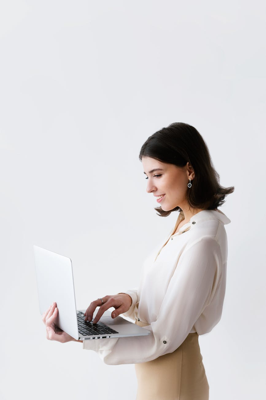a woman typing on laptop while standing