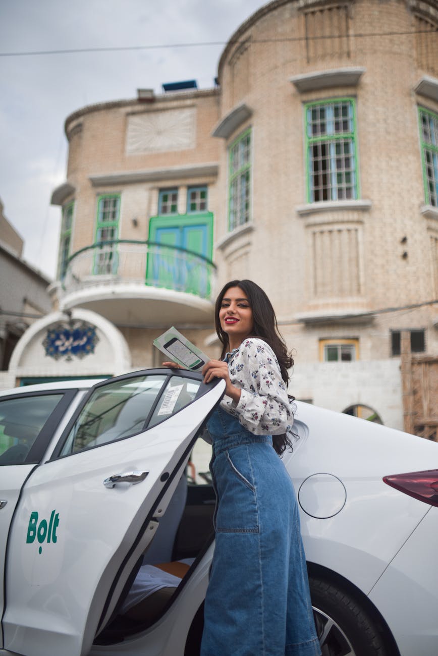 woman standing beside a white car