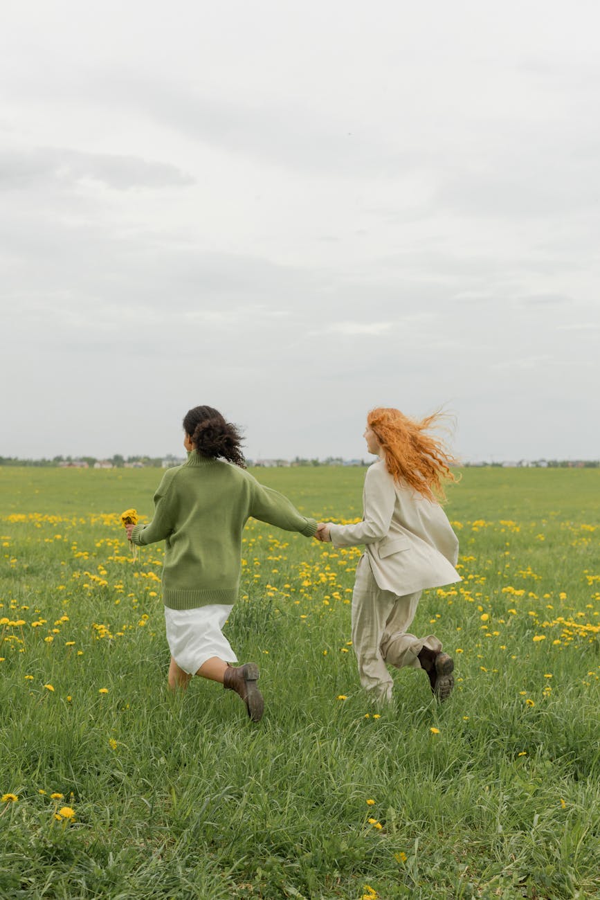 women running on a field while holding hands