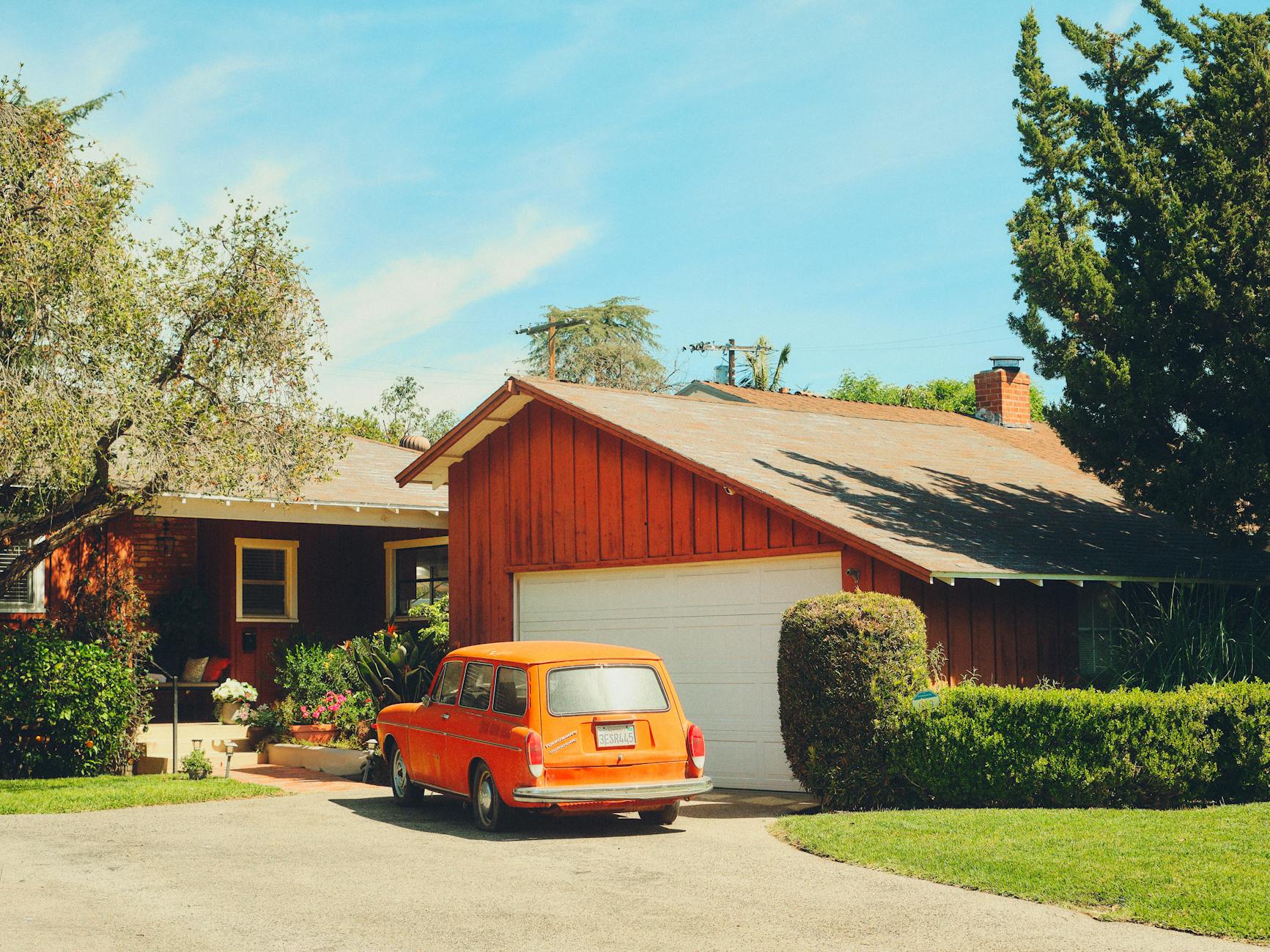 vintage orange car parked in suburban driveway