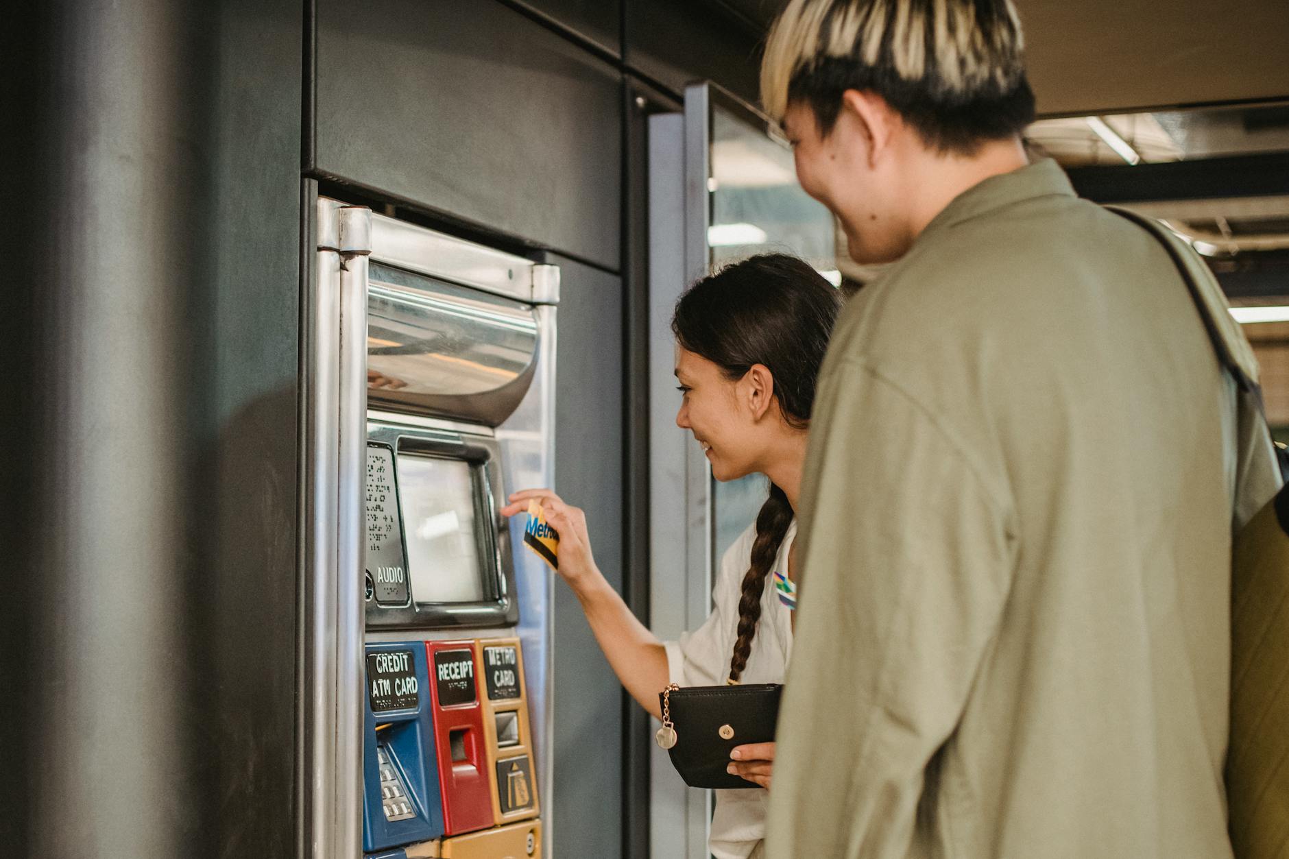 content couple using ticket machine in underground