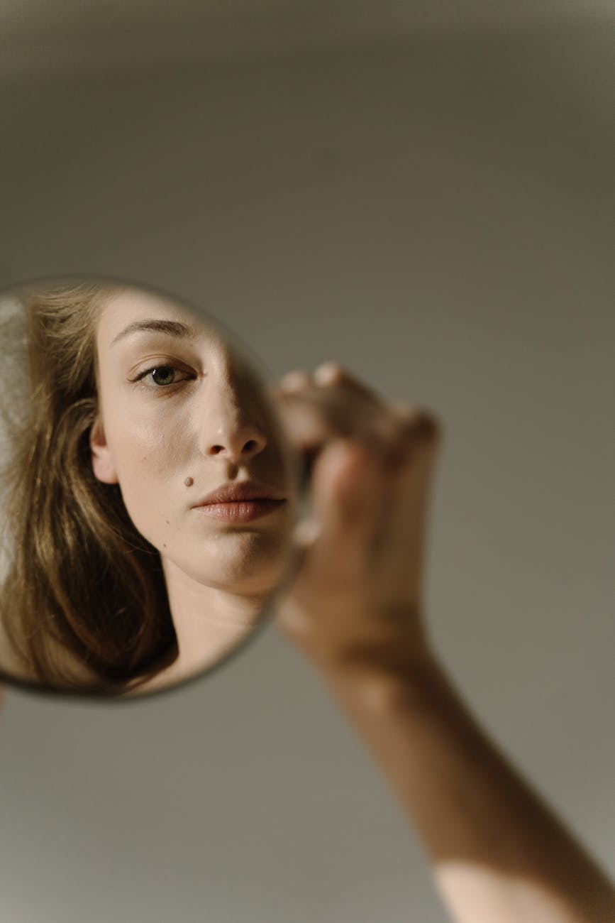 woman looking at her reflection in a mirror