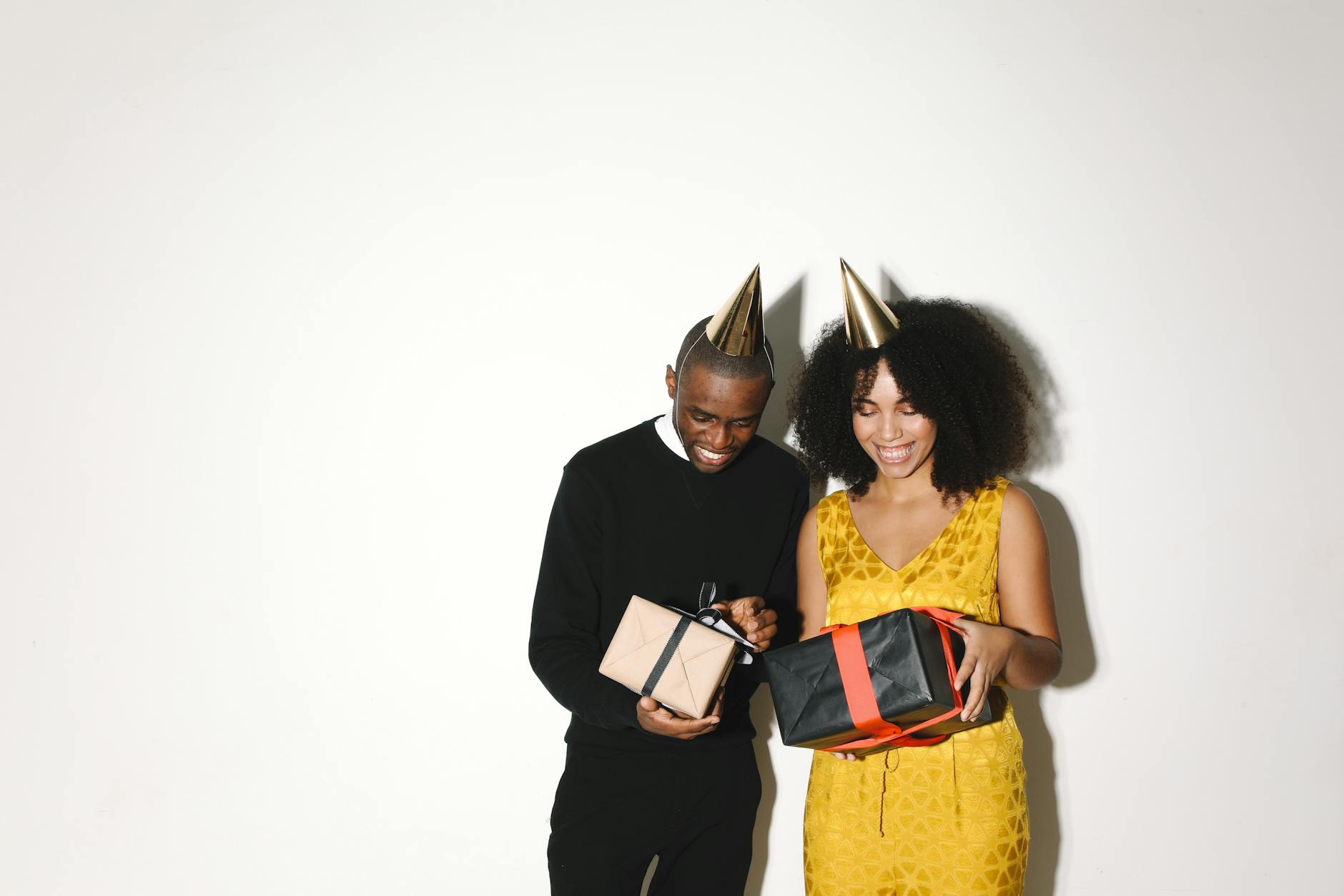a couple with party hats holding presents