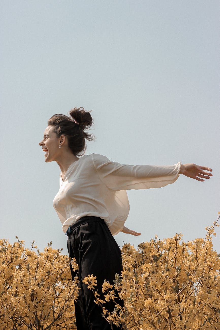 woman with arms open shouting in the flower field