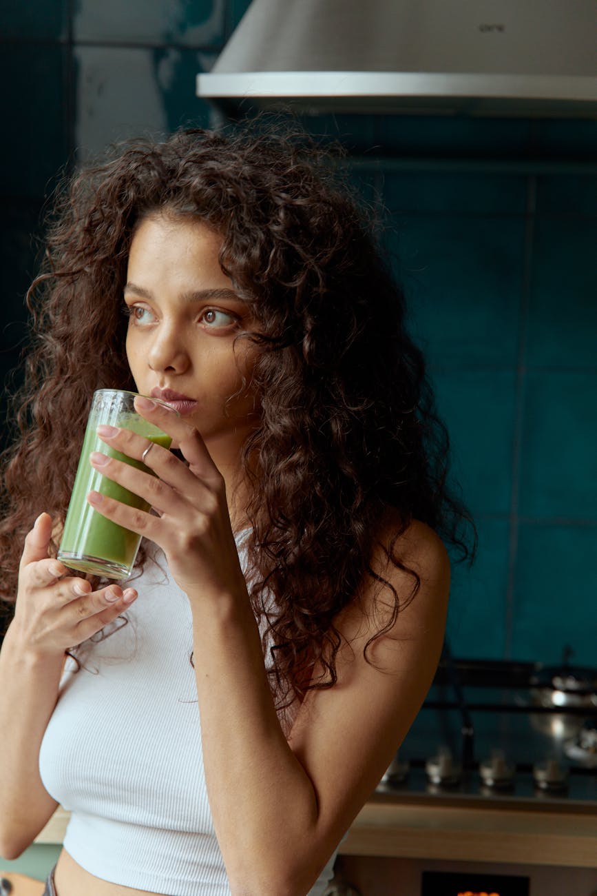 photo of a woman drinking a green liquid
