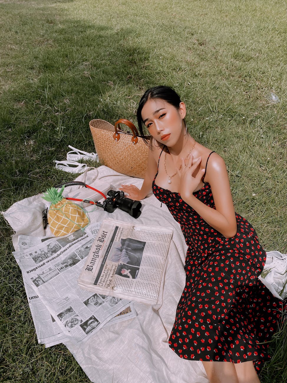 woman in spaghetti strap dress sitting on white textile