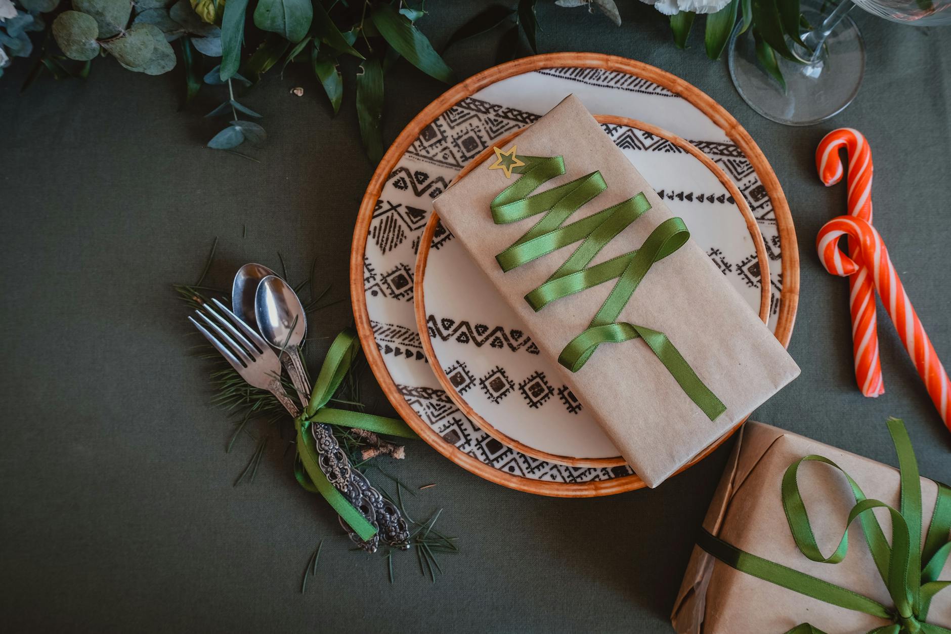 gifts with green ribbon on christmas dinner table
