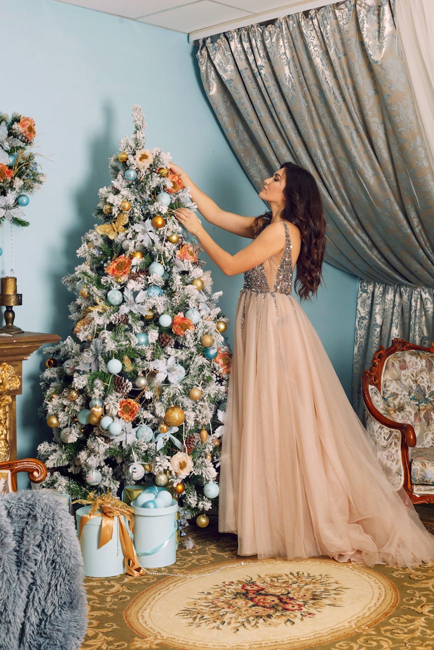 woman arranging white christmas tree