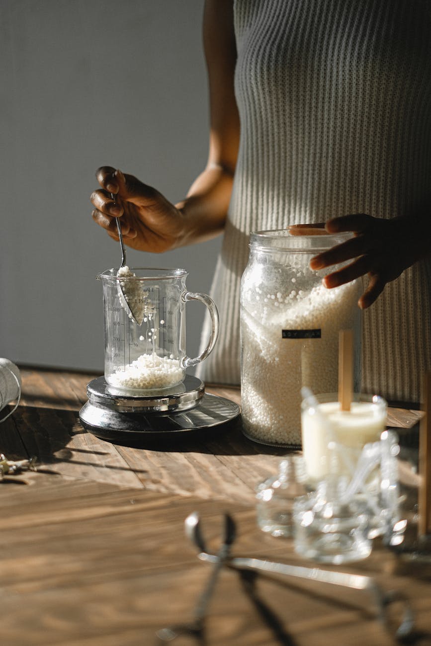 crop black woman pouring wax into jug