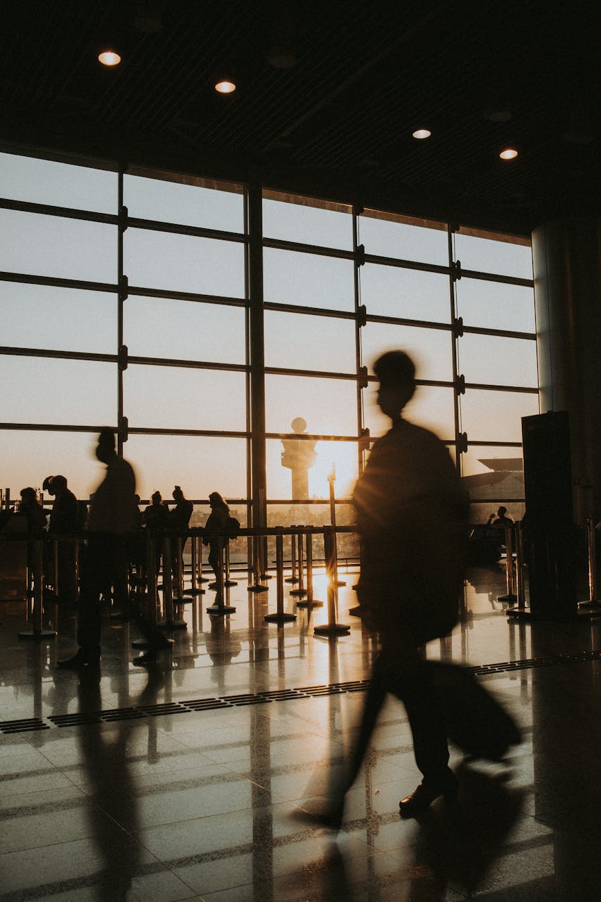 people walking at airport terminal at sunset