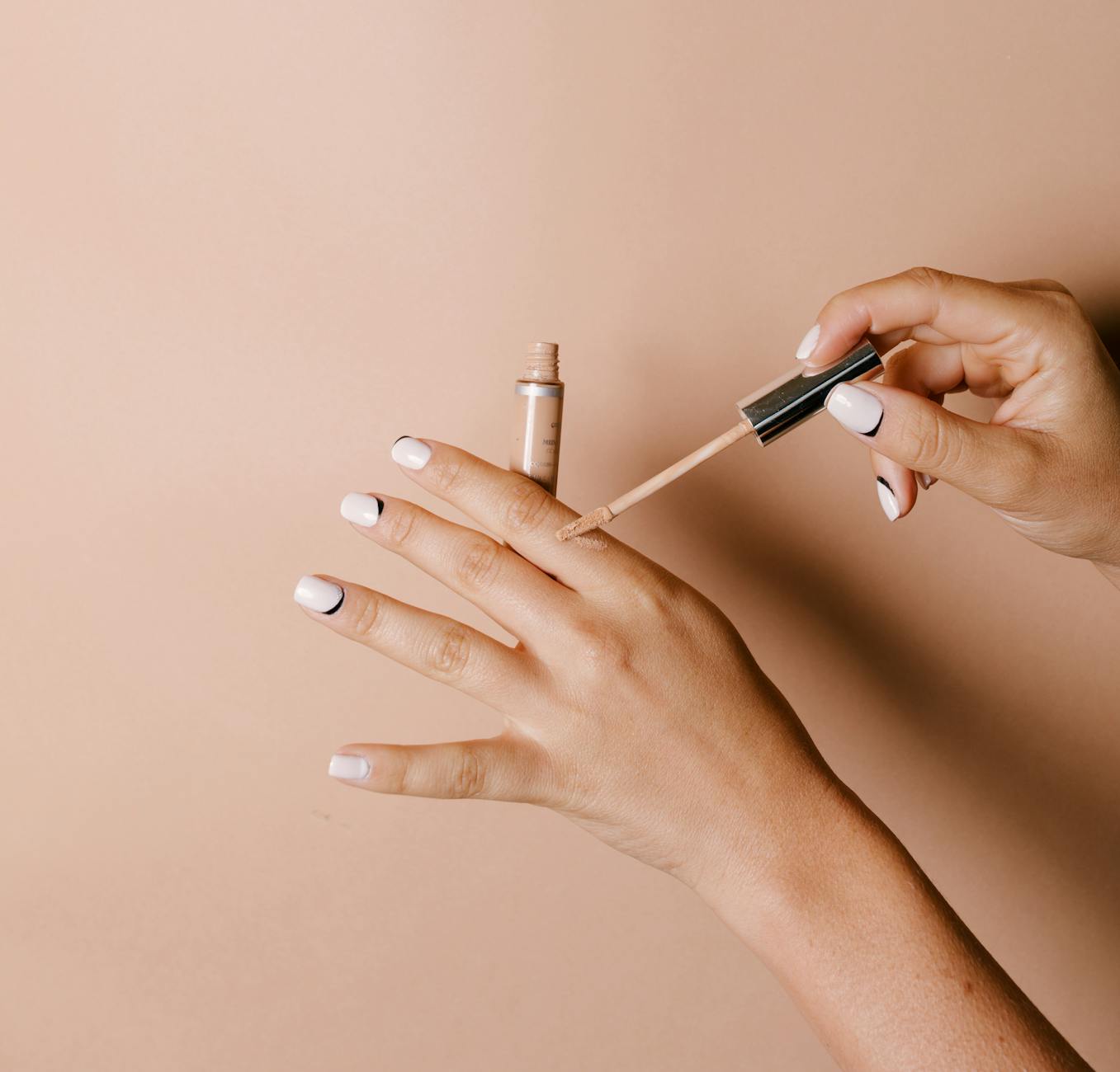 a person applying concealer on her hand