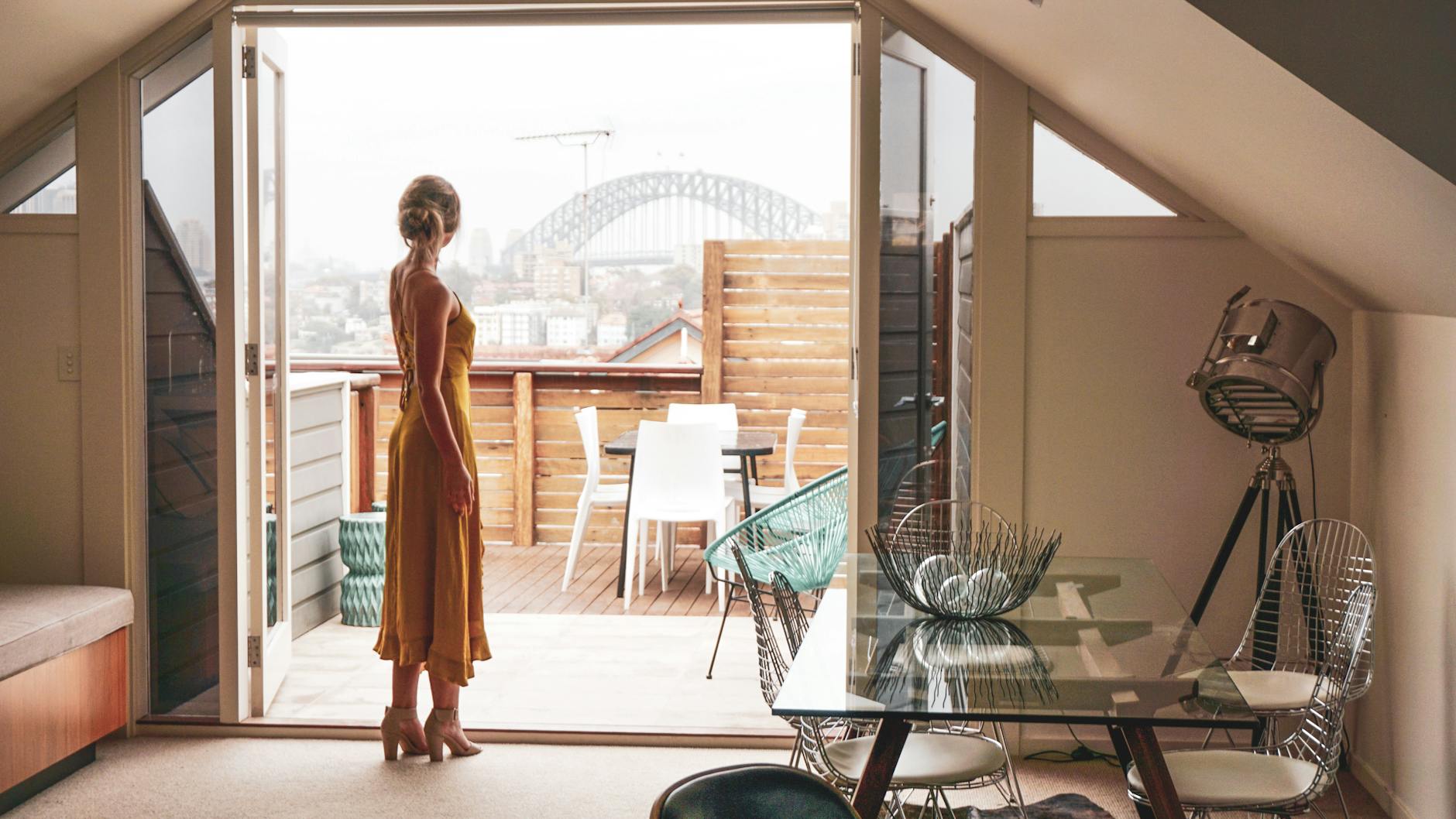 fashion woman model standing on open door to terrace