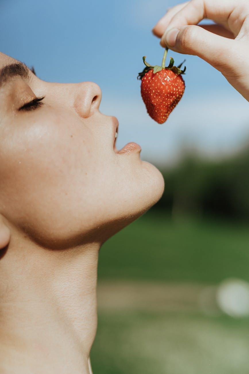 woman eating red strawberry