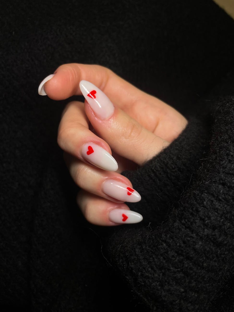 close up of acrylic nails decorated with heart shapes
