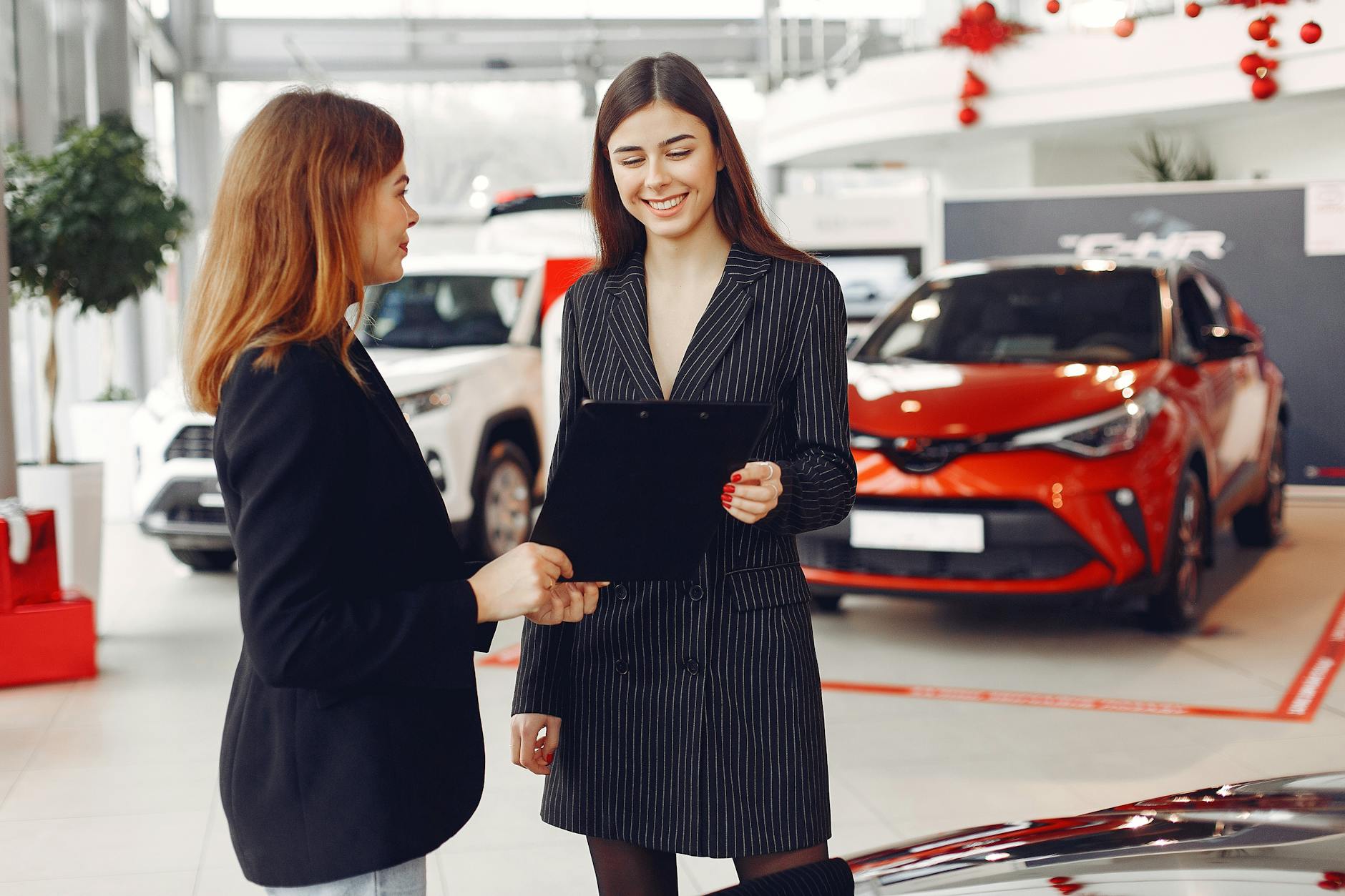 female car dealer holding a contract