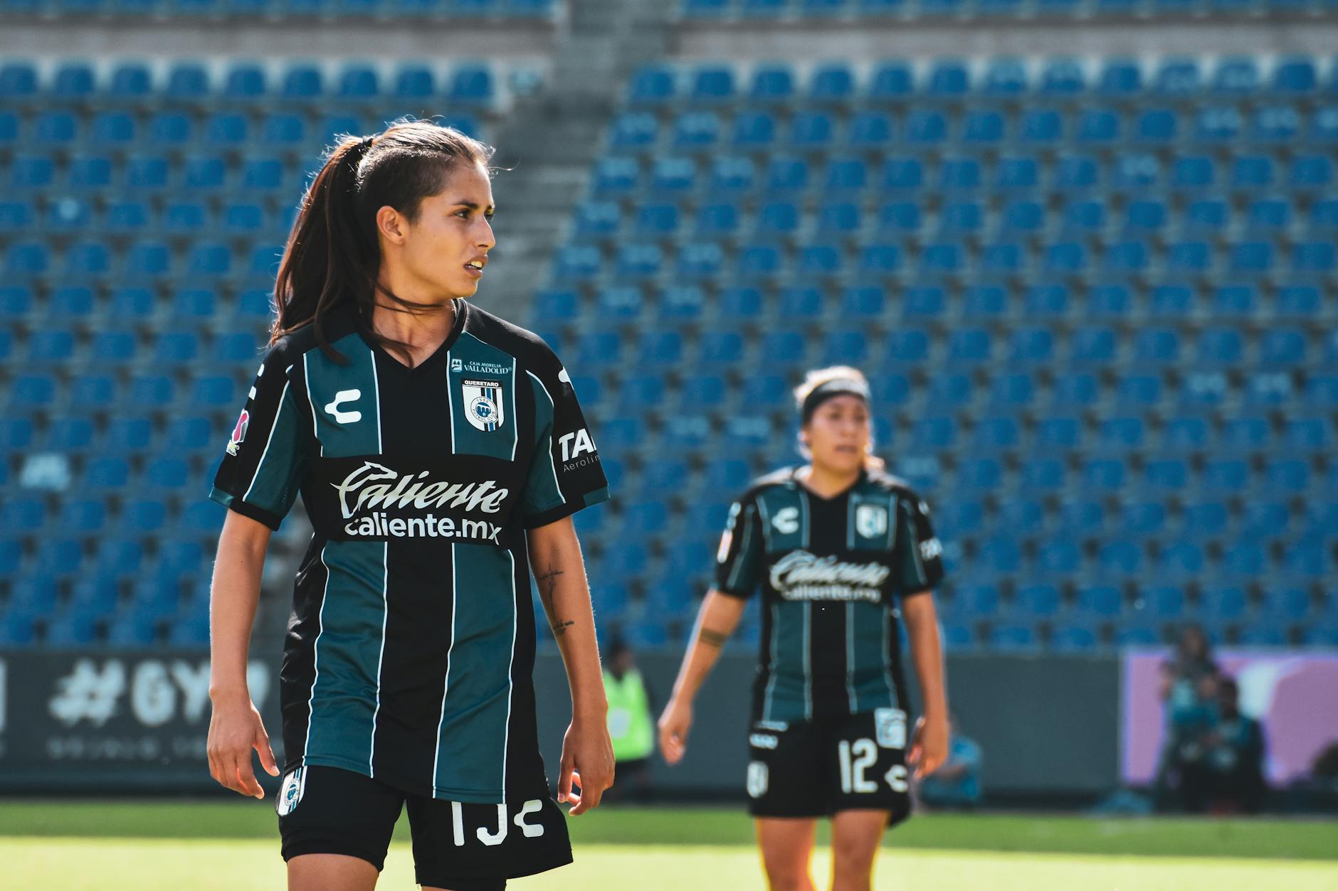 two women in black and white jersey uniforms standing on a field