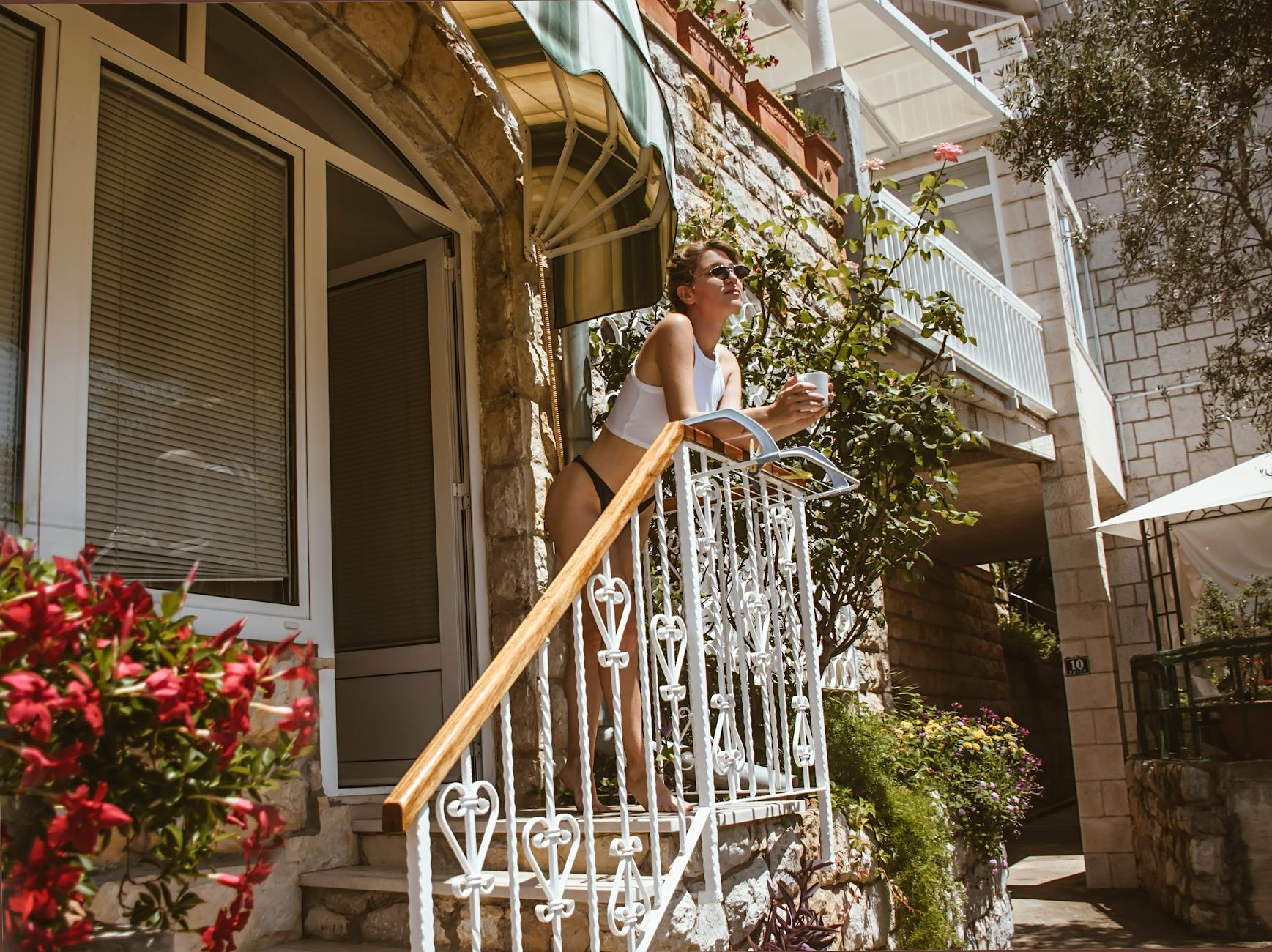 slender woman with morning drink on porch
