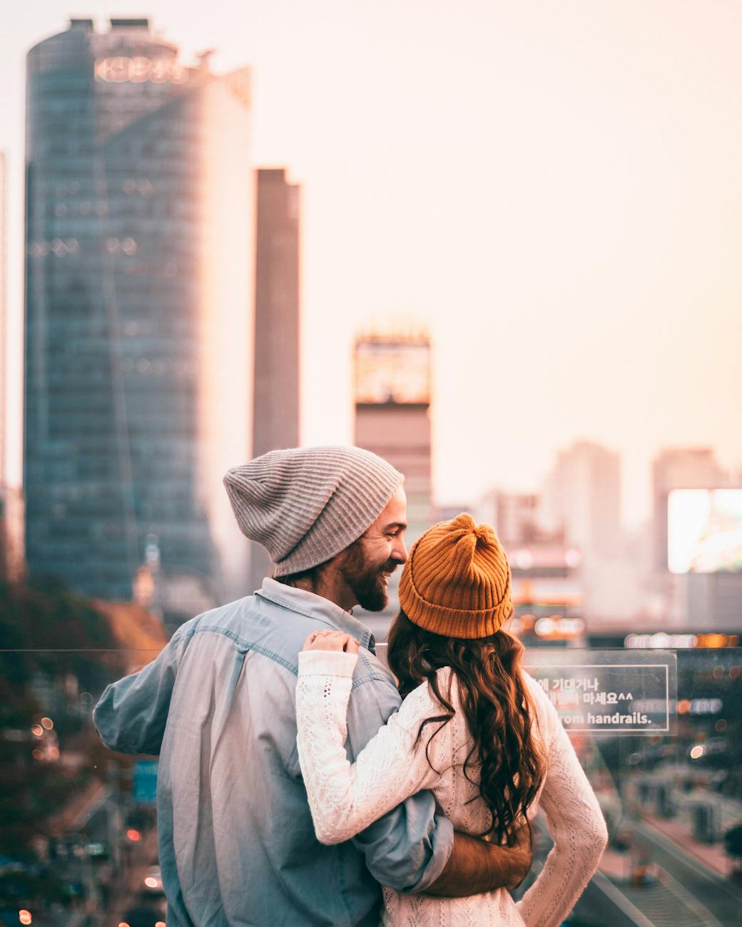 woman in gray jacket and brown knit cap standing on the city