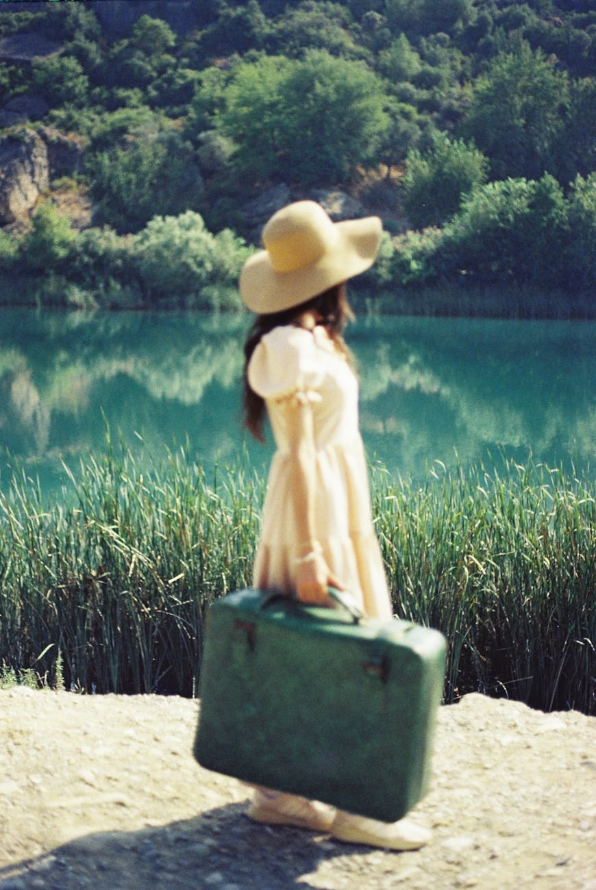 woman in dress and hat with suitcase
