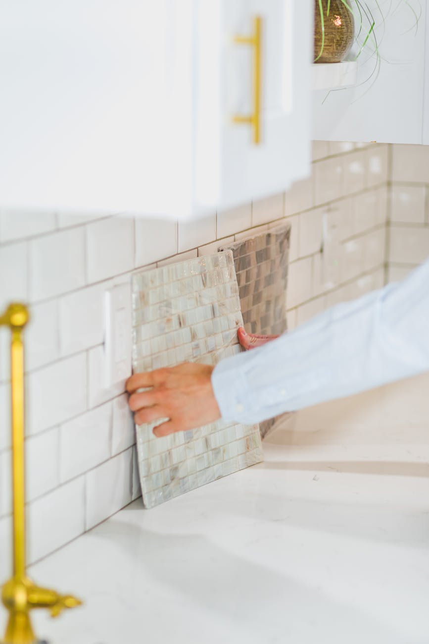 person choosing a tile design on wall