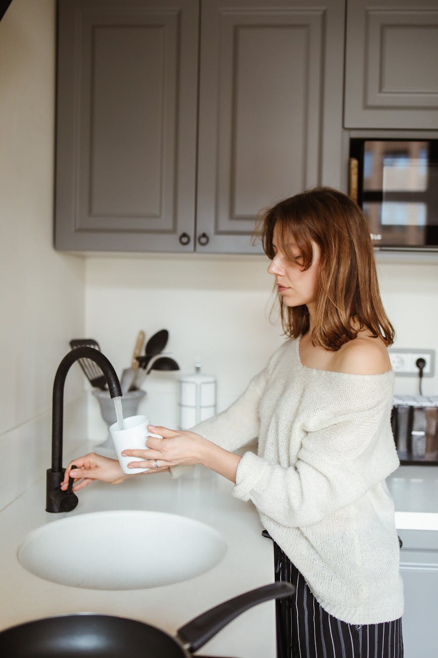 woman pouring tap water into a mug
