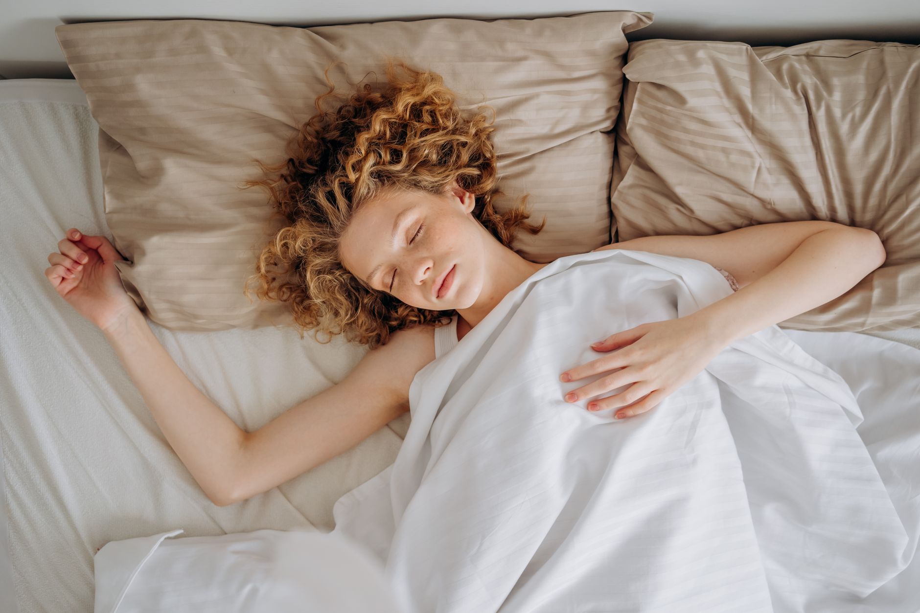 high angle shot of a woman sleeping on the bed