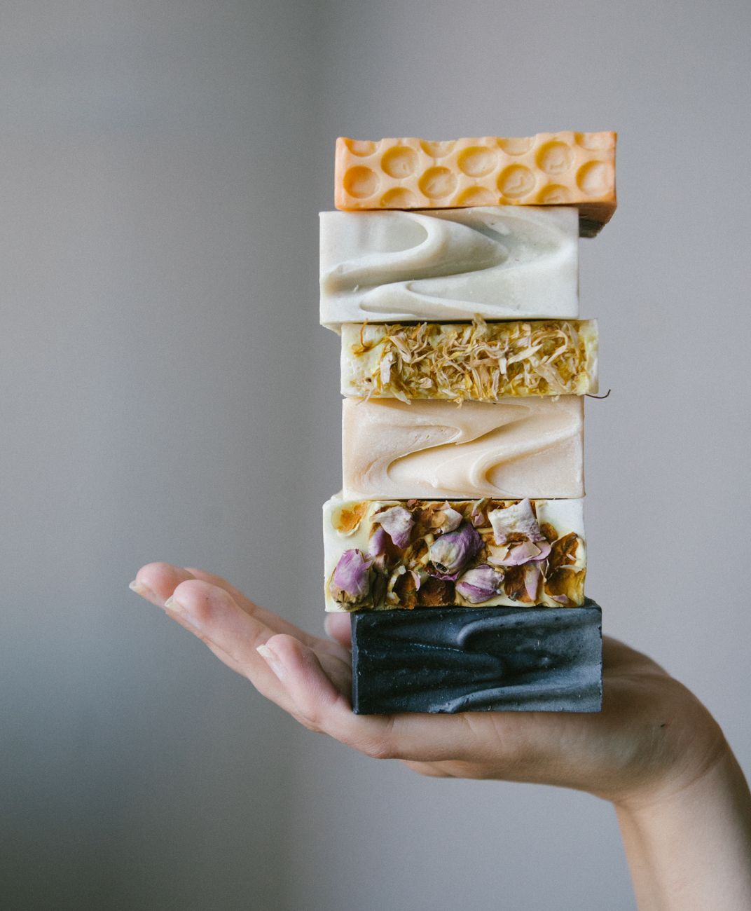person holding handmade soap bars