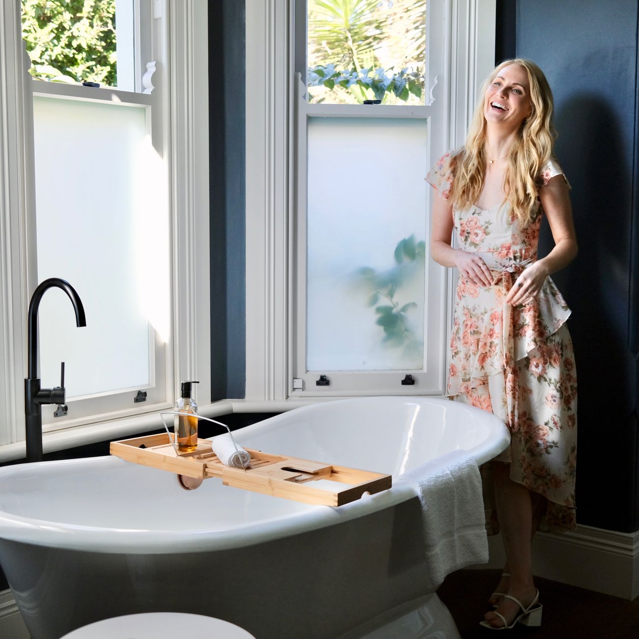 a woman standing near the bathtub