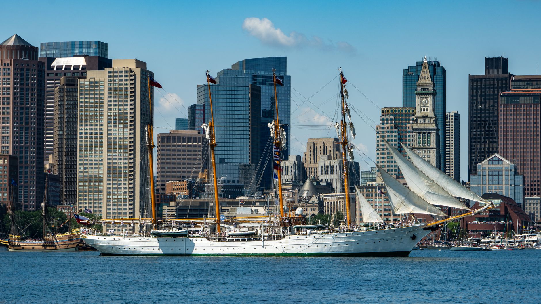 tall ship in boston harbor with skyline view
