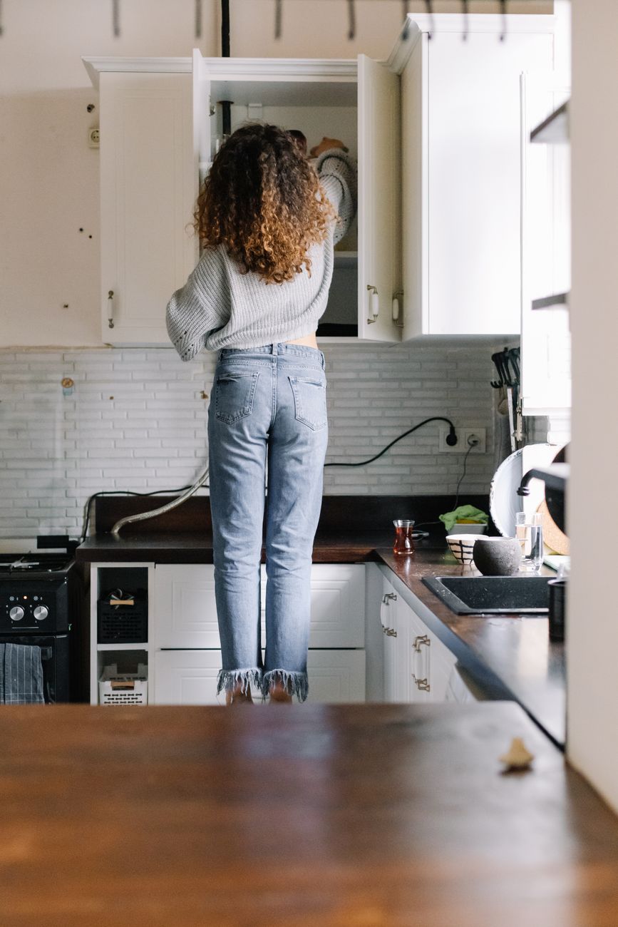 back view of a woman getting something from a cabinet