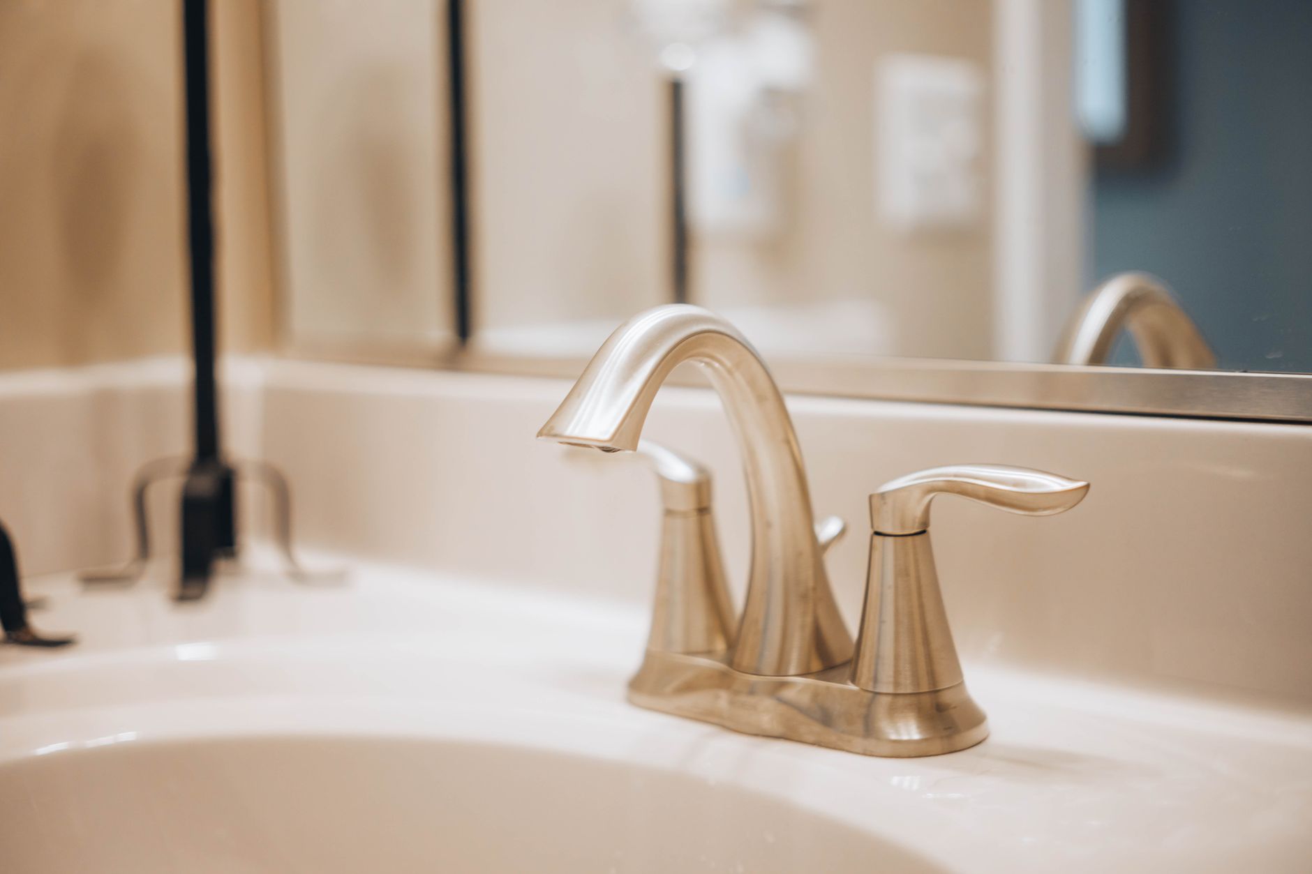 stainless steel faucet on white ceramic sink