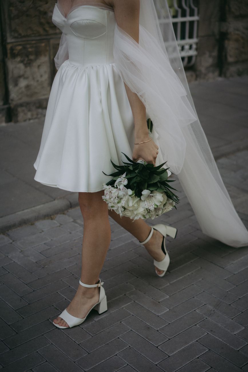 woman in white dress holding white flowers