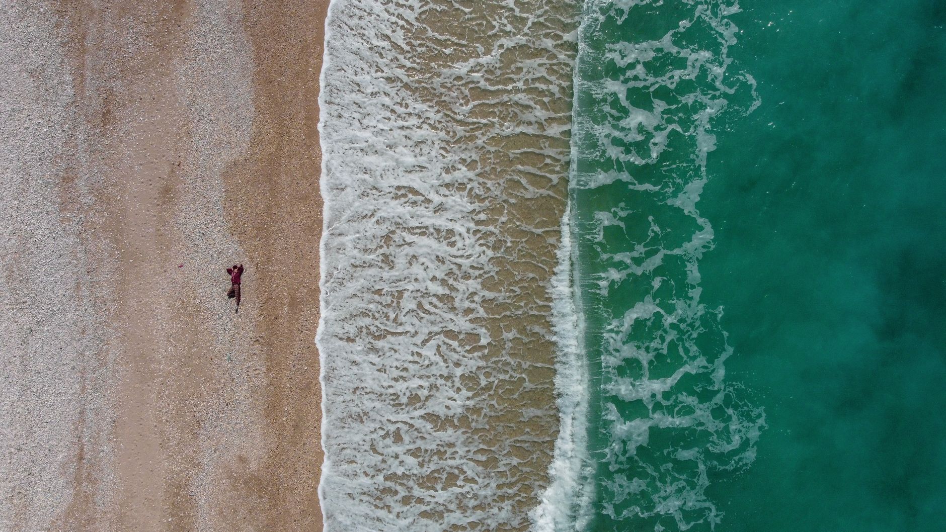aerial photography of ocean waves crashing on the sea shore