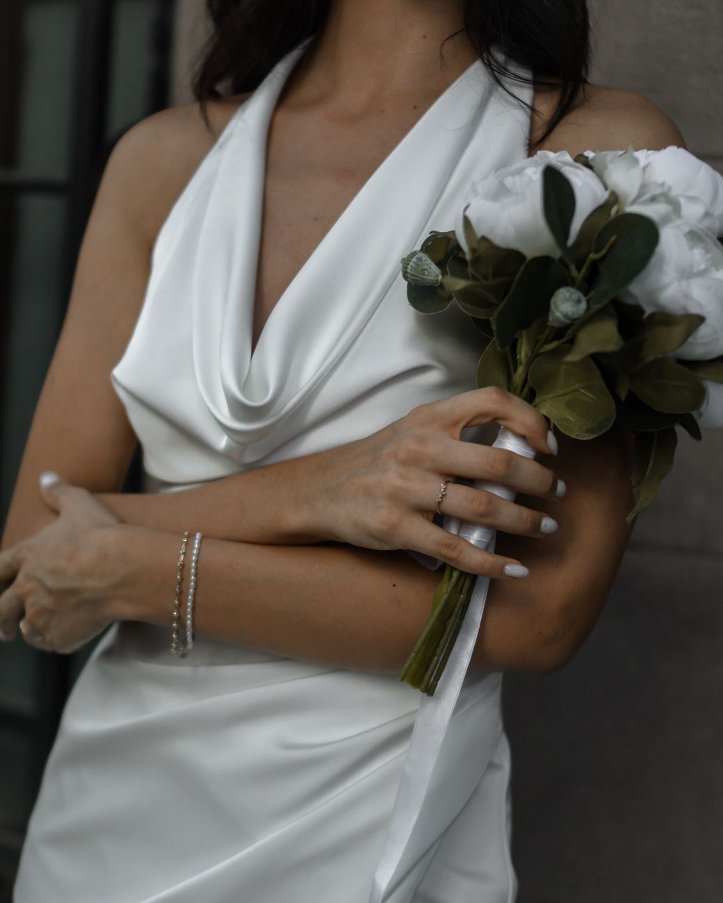 bride in a satin dress holding the bouquet