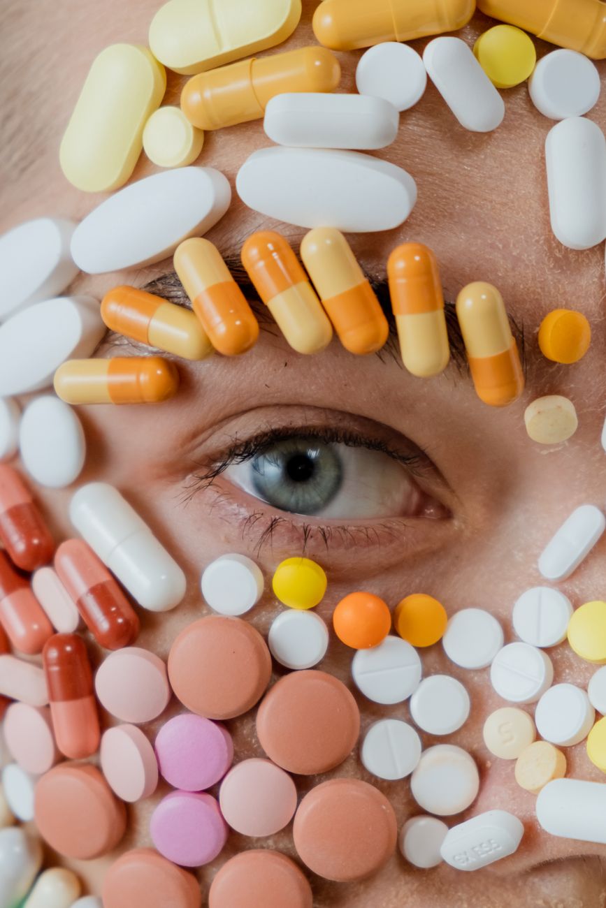 close up photo of assorted medicines surrounding a person s eye