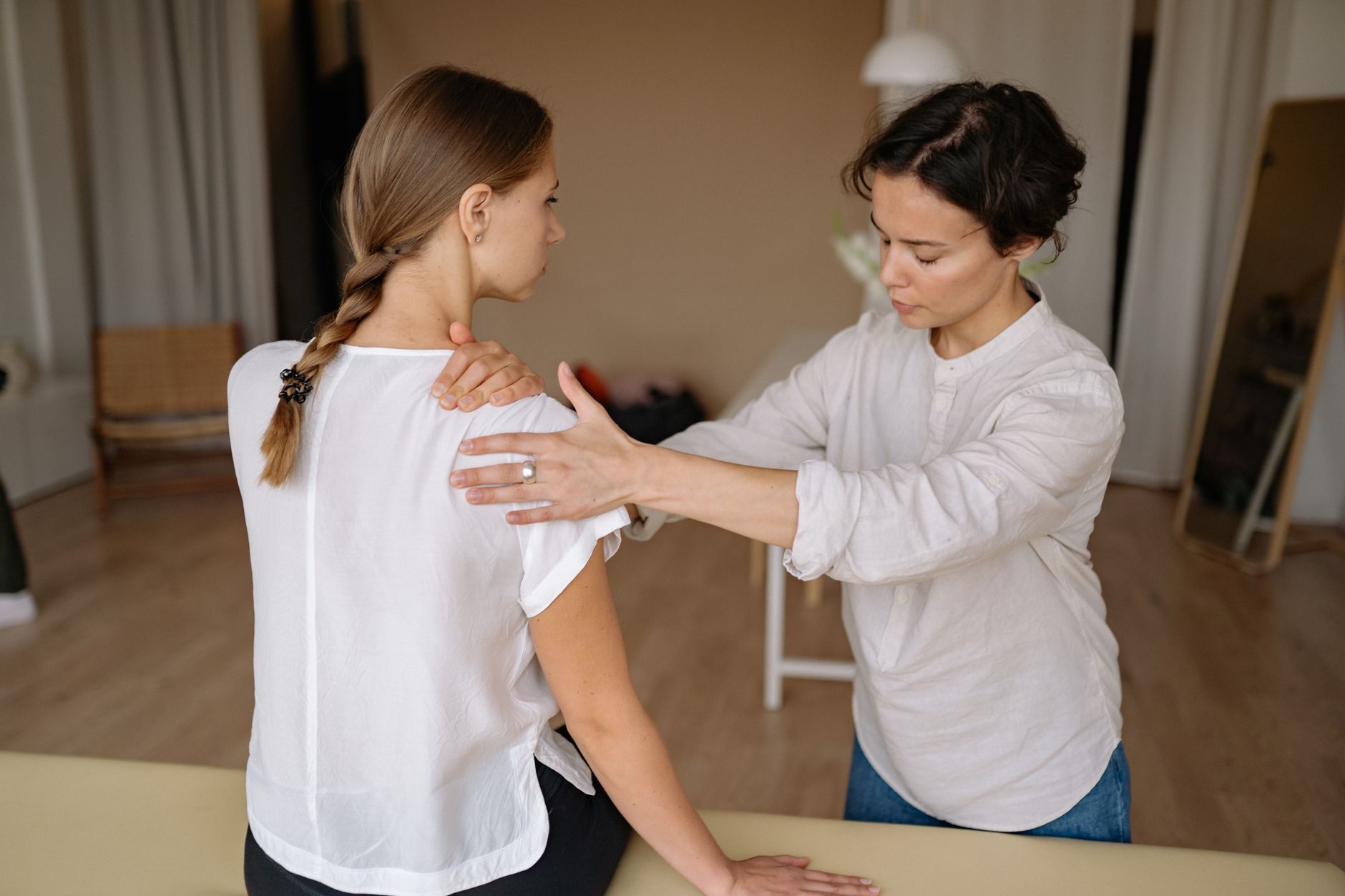 massage therapist massaging womans shoulder