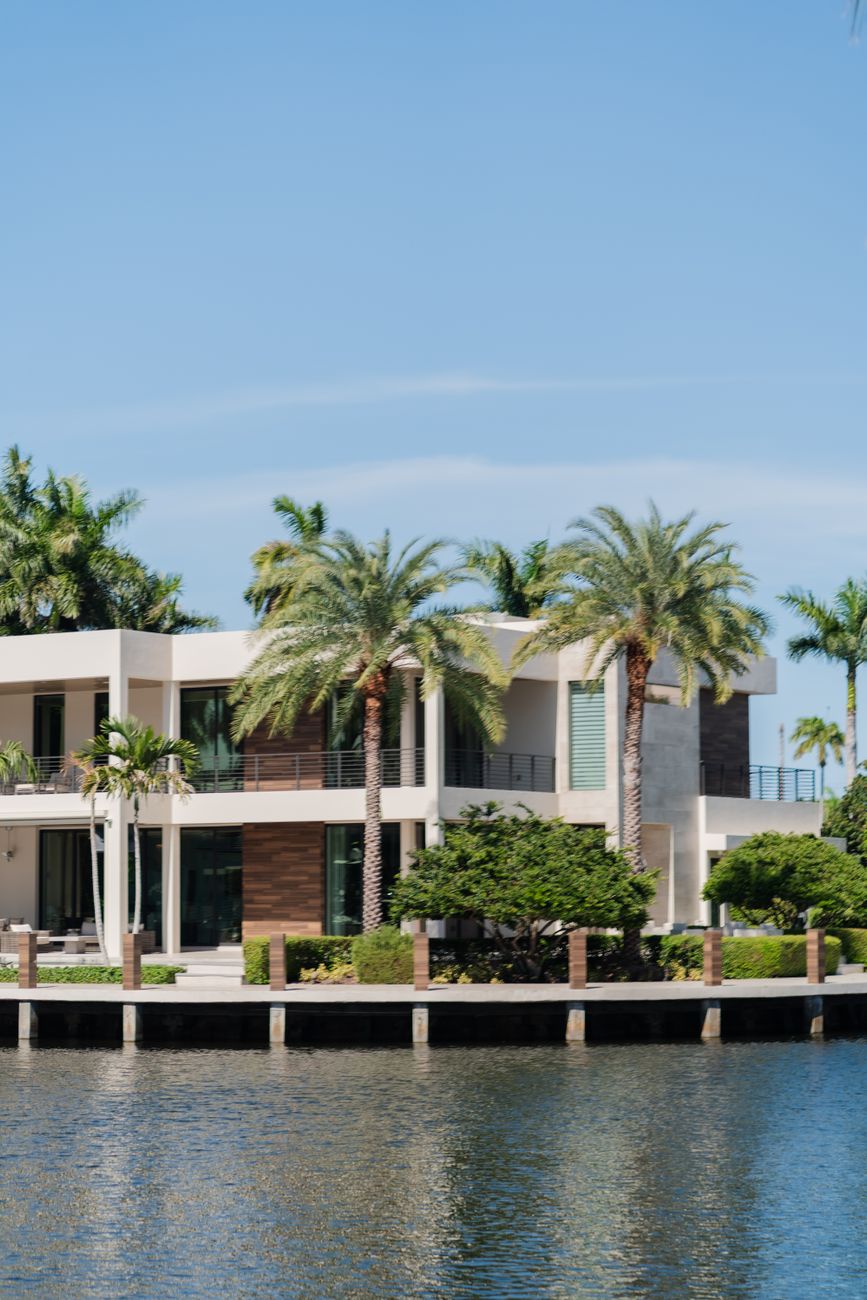 luxury waterfront villa with palm trees